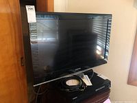Front view of Samsung 32 inch TV LCD TV model 32540P20 showing screen, bezel, and cables on the stand below.
