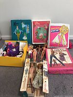 Group shot showing all cases, dolls, boxed dolls, modern fashion dolls, and yellow box of clothing