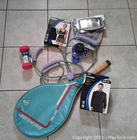 Overview photo showing all lot items including 3 lb dumbbell, sauna suit, hand grip exerciser, water bottle, armband, waist trimmer, and paddle ball set