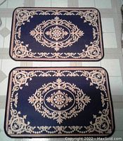 Two new navy blue and beige patterned rectangular floor mats, showing full top view of both identical mats side by side.