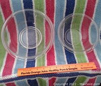 Two Pyrex clear glass bowls pictured on striped towel with measuring ruler showing 7 and 8.5 inch bowl sizes