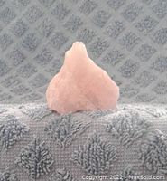 Side view of the rough rose quartz specimen showing pink color and texture.