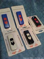 Five USB rechargeable lighters in original blister packaging, assorted colors: blue, black with red, black with white.