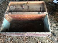 Interior view of open large vintage wooden tool chest showing inner compartments on lid and large open bottom storage area.