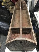 Photo showing empty large wooden toolbox with central handle on top and two compartments