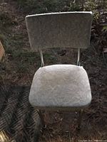 Vintage chair with cushioned seat and backrest, pale grey/white Formica surface with leaf pattern, chrome legs