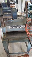Front angle view showing "16" Auto Planer" label, motor housing, infeed roller area