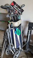 Image showing the golf bag filled with clubs, pull cart, and umbrella.
