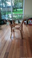 Full front view of round table showing glass top and rattan base