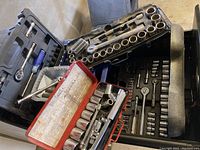 Four containers of sockets, ratchets, and accessories arranged with tools visible inside cases