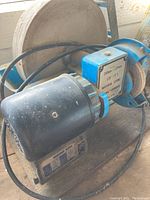 Close-up of one grinding wheel with blue metal base and black induction motor