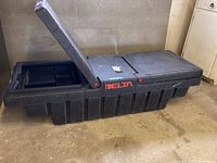 Black plastic Delta TrukMate truck box open showing multiple lids and compartments.