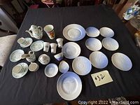 Overview of all pieces in the mini tea set showing plates and cups on a black surface.