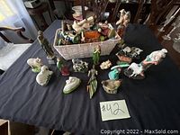 Top view of nativity figurines and stable arranged on black tablecloth. Includes various human and animal characters and the stable.