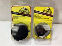 Front view of two Butler Creek scope covers sealed in original packaging, showing product labels and brand logos.