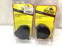 Front view of two new Butler Creek Flip-Open scope covers in their original packaging with flexible collars visible.