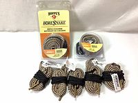 Photo of six braided rifle cleaning snakes for different calibers, two in packaging and four coiled with bands.