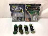 Photo showing two hunting video DVDs (Primos Truth 10 Bow Hunting and Mastering the Art of Turkey Hunting) and four cleaning ropes of different colors.