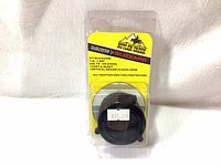 Photo of new Butler Creek Flip-Open Scope Cover 07 Blizzard in sealed plastic packaging, showing brand, model, size, and features on display card inside.