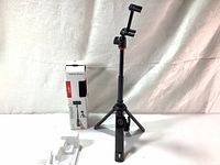 Full view of Joby 3000-178 Telepod tripod and packaging showing the tripod extended with phone mount and Bluetooth remote shutter on handle.