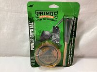 Front view of new Primos Power Crystal turkey pot call slate style in original packaging showing the circular amber crystal call and wooden striker on green cardboard backing with product branding.
