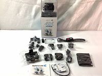 Full lot of the Safari 4K E action camera with all accessories laid out with box and manual visible.