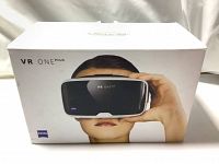 Box of ZEISS VR ONE Plus VR headset featuring image of person wearing headset, VR ONE Plus branding and ZEISS logo.