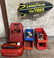 Fuel cans, storage bins with small parts, and Goodyear inflatable blimp shown hanging above.