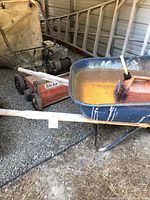 Snapper Thatcher lawn mower and blue wheelbarrow with red gas can, wooden ladder behind