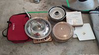 Overview of all bakeware items and red carrying case together on floor