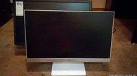 HP 23.5 inch monitor front view with silver bottom bezel and white stand