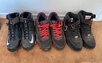 Full view of three pairs of Nike men's athletic shoes, size 13, including Air Force 1 sneakers and Swingman cleats with blue accents.