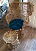 Wicker armchair and matching side table positioned on wooden floor near doorway