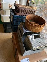Multiple baskets stacked including rectangular, square, and round types in various colors and materials, shown near a window.