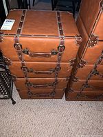 Front view of the four drawer chest showing the faux leather with buckle accents and the overall style.