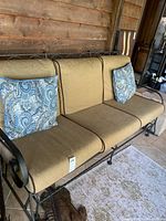 Full front view of three-seat glider with cushions and pillows