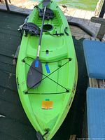 Full overview of kayak on dock with paddle laid across