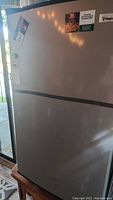 Front view of Magic Chef mini fridge showing silver front door with magnets.