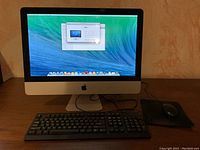 iMac with keyboard and mouse on desk showing desktop screen