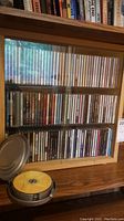 Wooden case with glass doors filled with rows of CDs