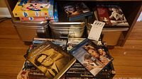 Metal boxes and bins filled with assorted DVD cases, some visible titles and boxed set.