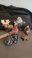 Overall view of the seven Artesania Rinconada ceramic figurines arranged together, showing different angles and shapes