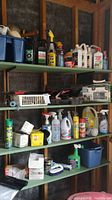 Wide view of shelves with various home and auto support supplies including spray bottles, cleaning liquids, and boxes.