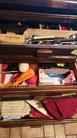 Lower drawers showing aprons, dish cloths, and some loose kitchen tools including peelers and measuring items.