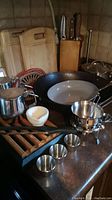 Full view of kitchen items including boards, cookware and serveware on counter