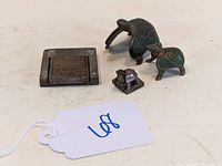 Photo showing all four items: two large turtles, a small turtle, and a tiny duck, plus one metal seal base plate.