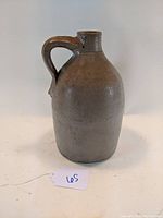 Front and side view of antique 9.5 inch salt glazed stoneware jug showing handle and surface details.