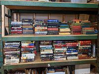 Wide shot showing multiple shelves filled with tightly packed hardcover books including various authors and genres, some with dust jackets.