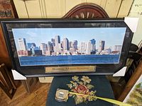 Frontal view of large framed panoramic photo showing Boston skyline, with label 'Boston, Massachusetts'