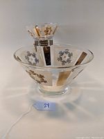 Front angle of Mid Century glass chip and dip set showing gold and silver floral and geometric patterns.